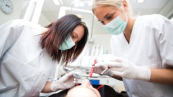 två tandläkare som jobbar med en patient. Foto:Mostphotos