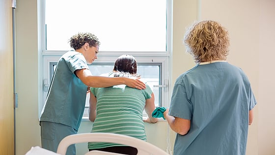 Två sjuksköterskor som tar hand om en patient i smärta. Foto: Mostphotos