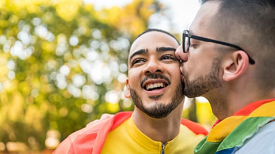 Two persons kissing on the cheek