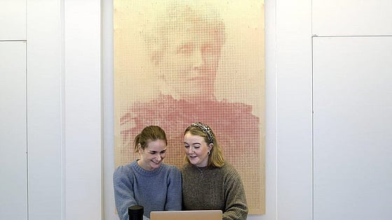Studenter som sitter framför en tavla föreställande Emmy Rappe