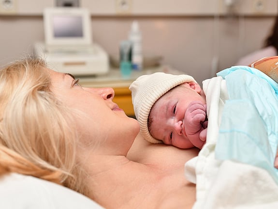 Mamma med sitt nyfödda barn på bröstet. Foto:Mostphotos