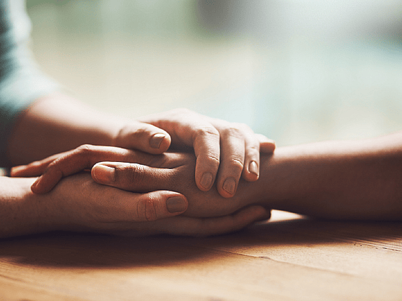 Två personer som håller om varandras händer. Foto: Mostphotos.