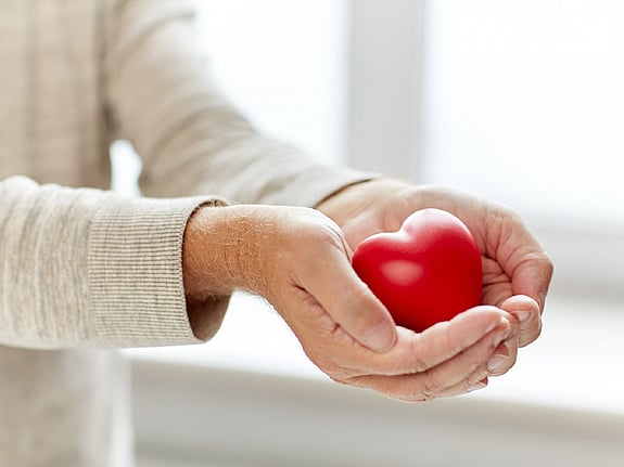 Person som håller ett rött hjärta i sin hand. Foto:Mostphotos