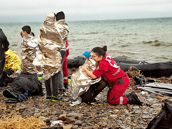 Flyktingar som mottas vid en strand av Röda Korset frivillig. Foto:SRK