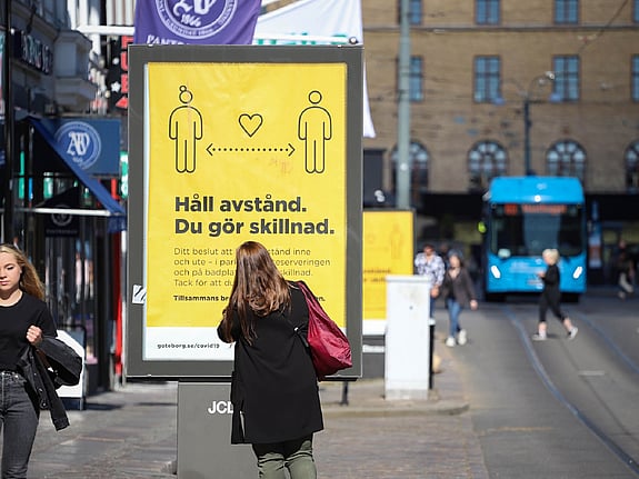 Bild från en gata i Sverige under covid-19 pandemin med uppmaning om att hålla avstånd. Foto: Mostphotos.