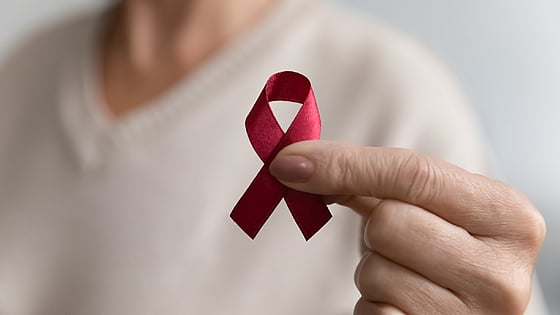 Kvinna som håller upp hiv/aids-symbol. Foto:Mostphotos